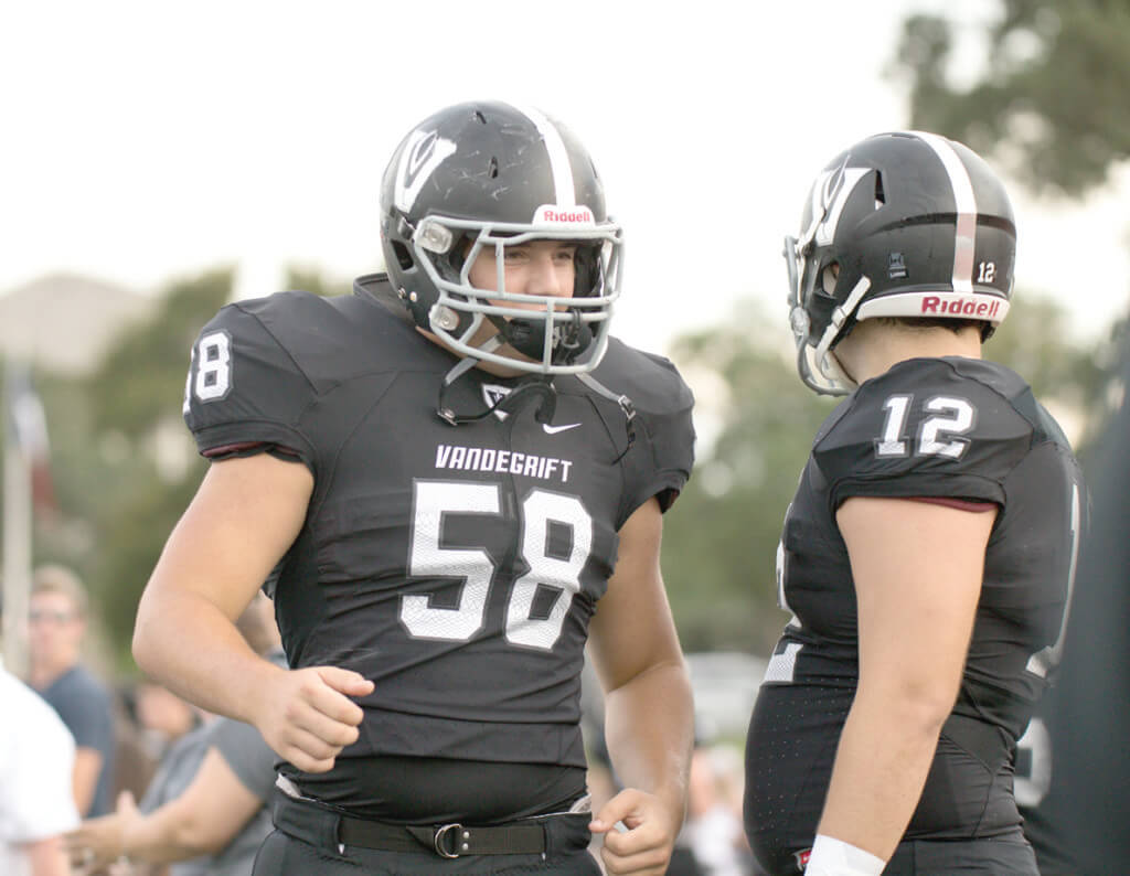 Vandegrift Vipers senior lineman Jim Hauck (58) talks with senior offensive lineman Holton Greenfield (12) before a high school football game between the Vandegrift Vipers and the Permian Panthers at Monroe Stadium in Austin, Texas, on August 26, 2016