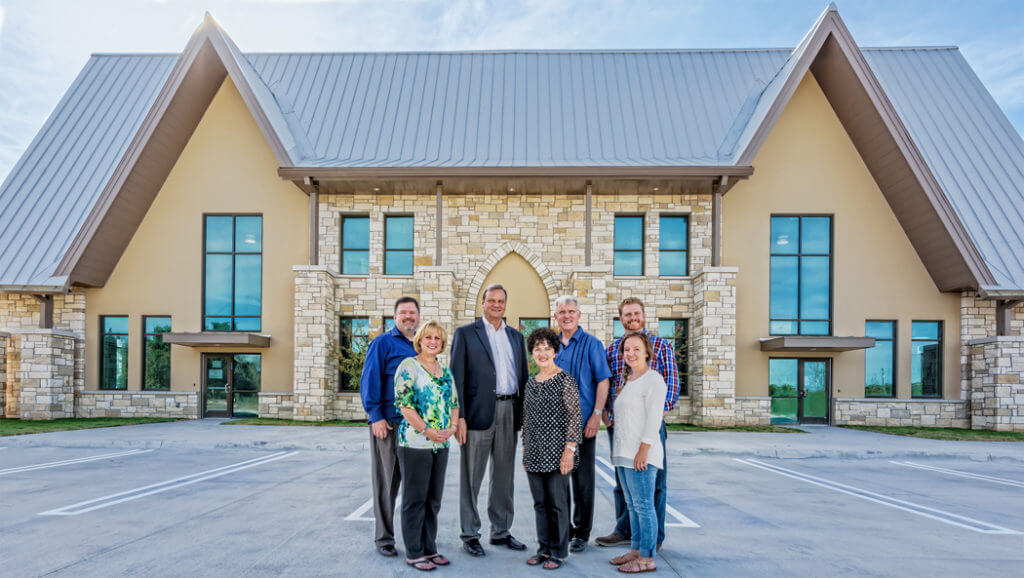 While finishing touches are made inside, Austin Baptist Church staff members stand outside ABC’s new education building scheduled to open on Aug. 28. L-R in front is Cathy Smith, minister to children and their families; Dodie Morris, music and worship associate; and Kati Dobbs, children’s ministry assistant. In back is John Parker, associate pastor of music and worship; Gary Dyer, senior pastor; David Procter, executive pastor; and Matt Gillum, minister to students and their families.