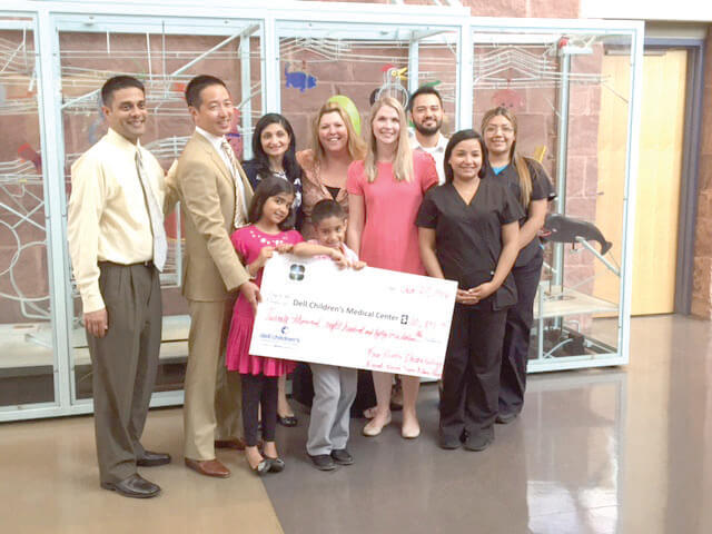 The Bhatt family of River Place collected $20,841 for Dell Children’s Medical Center and recently presented the check (L-R): Dr. Kunjan Bhatt, Dr. Mark Shen, president of Dell Children’s, Dr. Roopal Bhatt and Four Points Dermatology staff members: Kandena Ramirez, Jill Hude, physician assistant, Edgar Corrales, Maritza Mendoza and Carmen Navarro. In front are the Bhatt children, Sapna and Devan. 