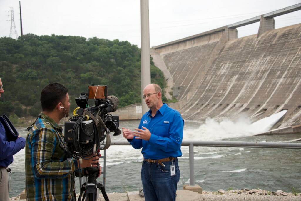 LCRA general manager Phil Wilson speaks with media at Mansfield Dam on Monday, when one of the floodgates was opened. Hundreds of people came out to watch the event. Wilson, a local Four Points resident, was encouraged to see so many kids watching the event and seeing first hand how a dam works. 