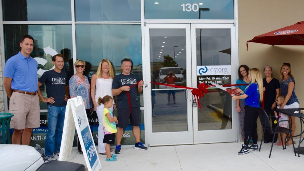 Restore Cryotherapy opened its third Austin-area store at the Hill Country Galleria on June 13. Steiner Ranch resident Steve Welch, second from left, and business partner Jim Donnelly, holding the ribbon, and their families and Restore team members celebrated the opening of the Bee Cave store. 