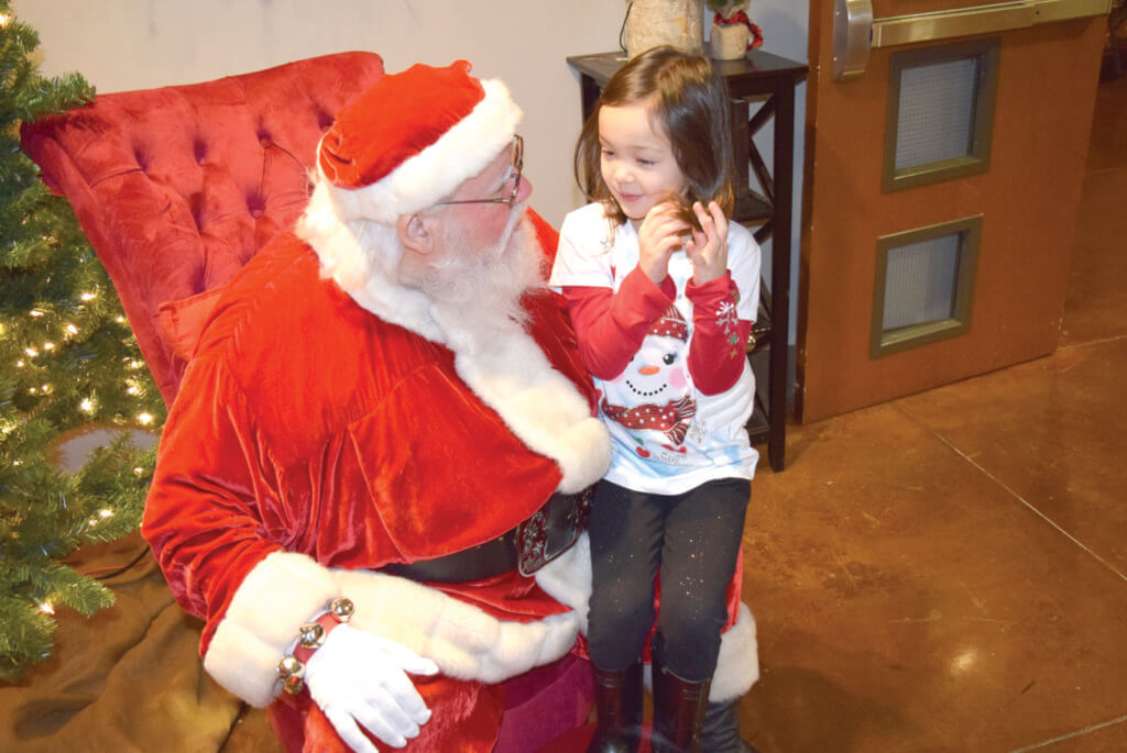 A shy Sophie Stevens gives her wish list to Santa.