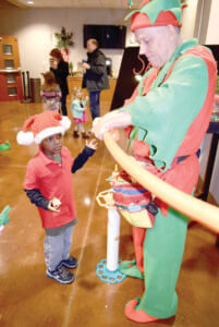 Balloon artist, Jack Byrd, fashions a sword for Henry Smetana. 