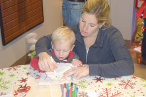 Elissa Kanatzar helps her son, Grant, write a letter to Santa.
