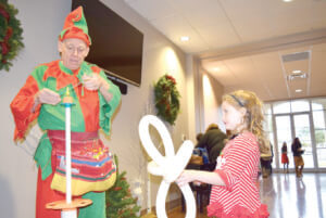 Balloon artist, Jack Byrd, crafts a Christmas rose Claire Washington.