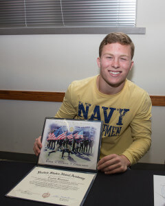 Vandegrift High School senior running back Travis Brannan shows his official letter of commitment to attend the U.S. Naval Academy to play football.